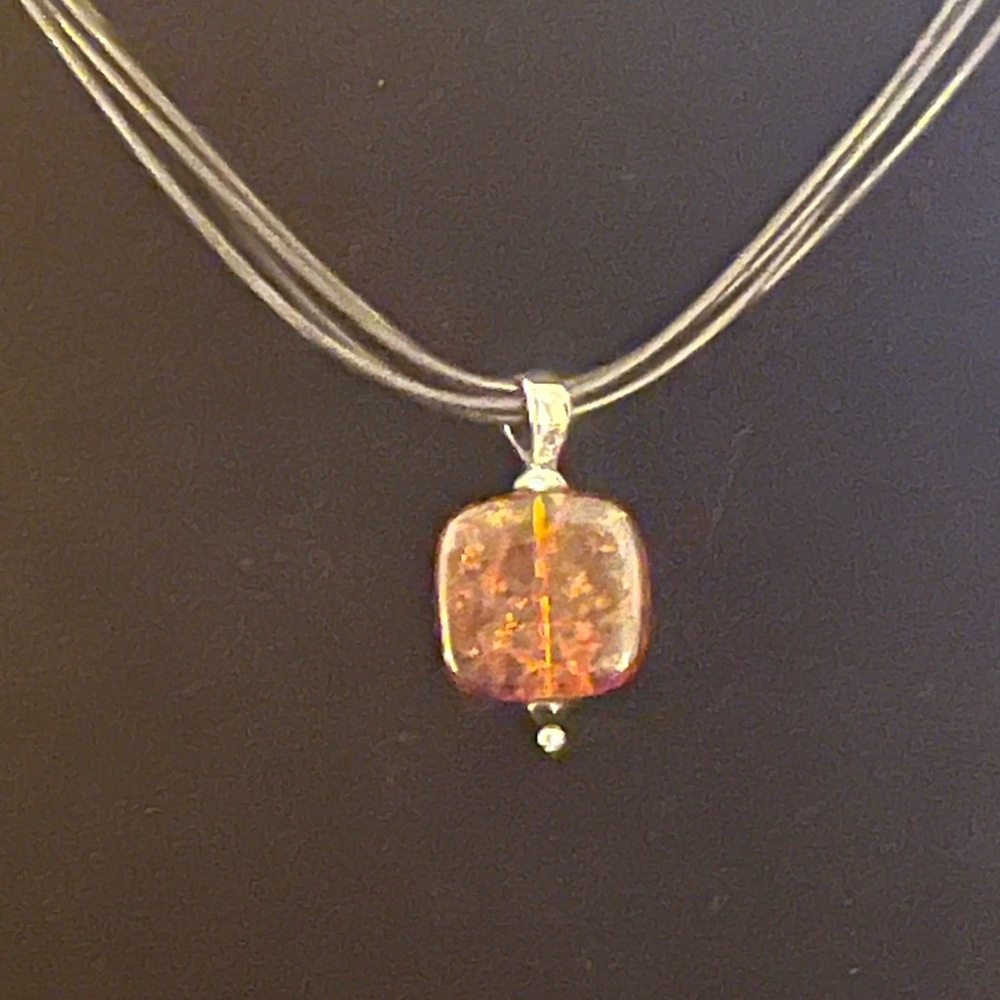 Silpada An Amber, Black Onyx Pendant on a four Strand Black Leather Necklace.